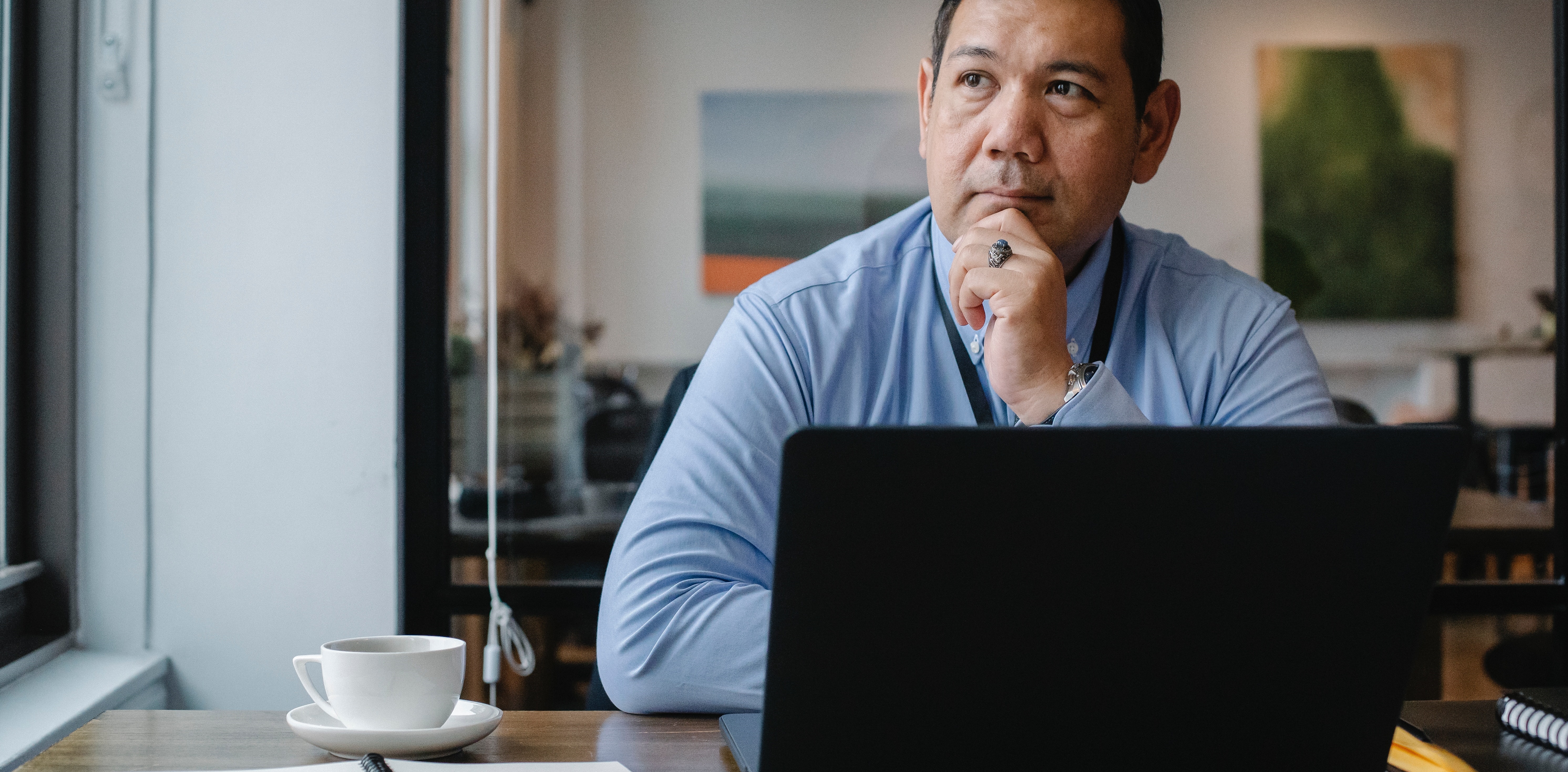 man denkt na achter zijn laptop